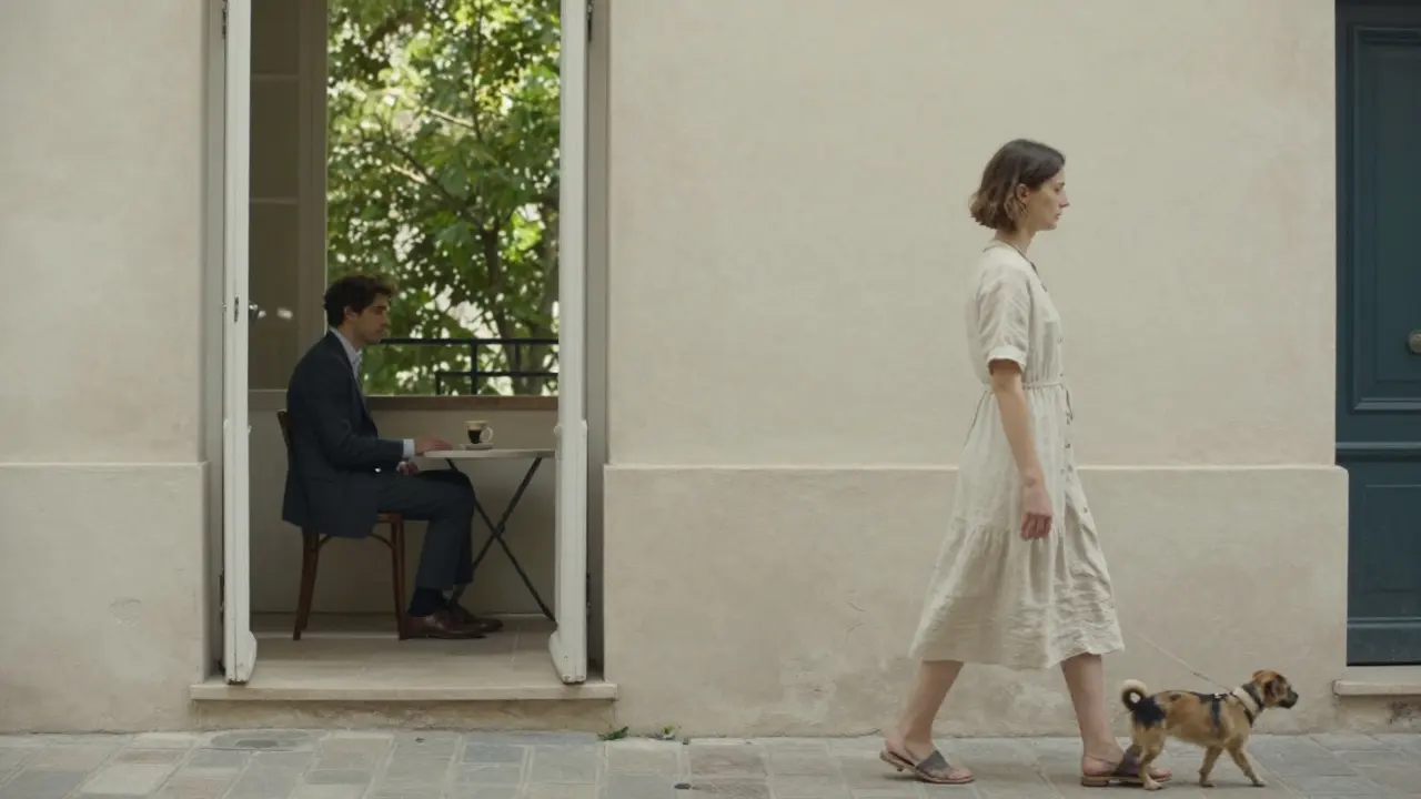 A woman walks a dog in a Le Marais courtyard while a man looks out a window, morning light filtering through trees.