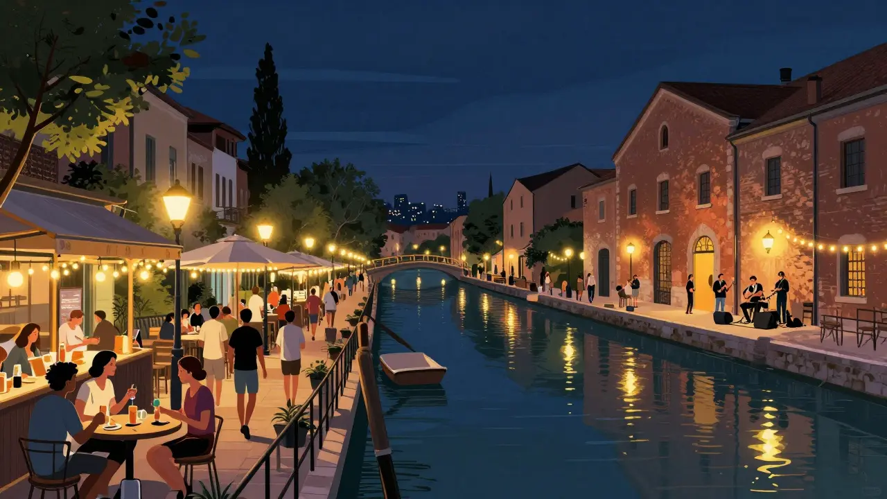 Nighttime scene of Milan's Navigli canals with people walking between lit terraces and live music.